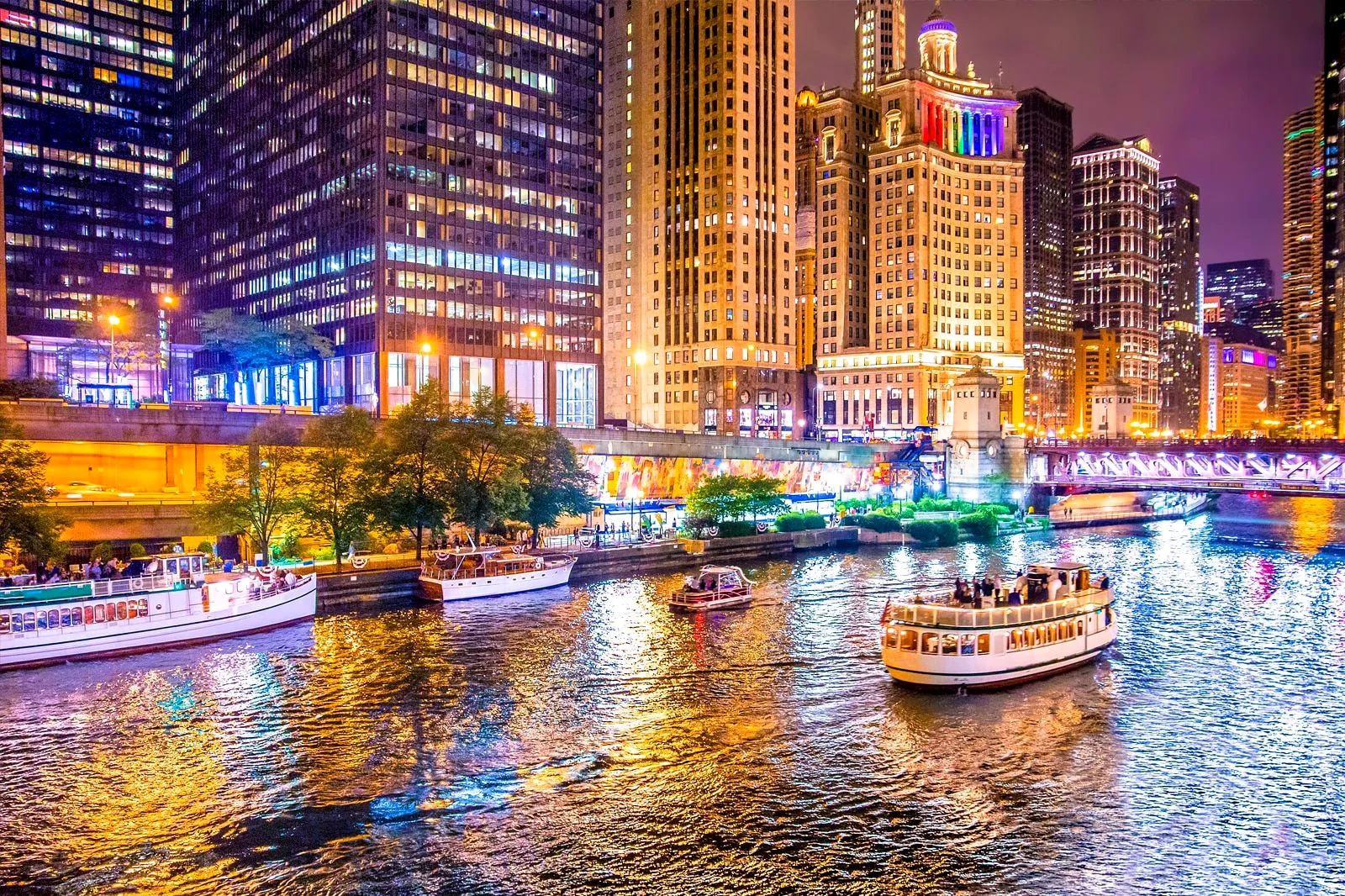 Chicago Riverwalk with tour boats at night
